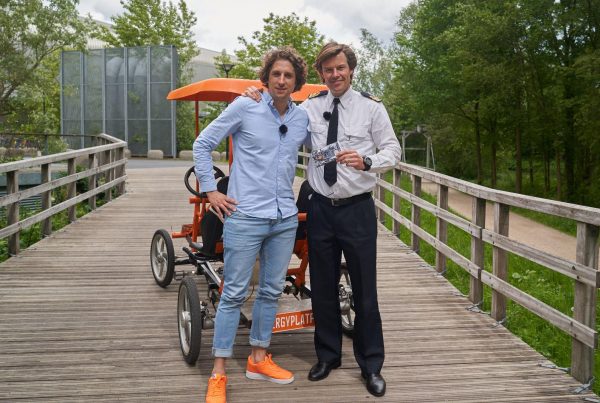 Tijs en Berend op een brug in Utrecht, staand voor de oranje fiets en pratend over vitale medewerkers