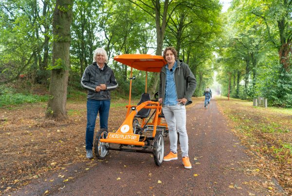 Jan Dekker en Tijs Koedam voor de oranje fiets, voor de aflevering 'Goed voeding is de basis voor vitaliteit'