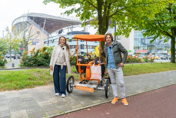 Sabine en Tijs voor de oranje fiets, pratend over stress verminderen door altijd een dokter op zak te hebben